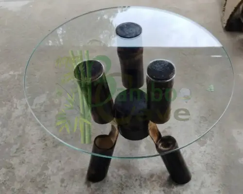 This unique bamboo centre table is a striking blend of craftsmanship and contemporary design. Carefully created using bending bamboo works, the structure showcases the natural strength and flexibility of bamboo, shaped into smooth, flowing forms that support a sleek circular glass top. The rich, charred finish enhances its texture, giving the piece a bold yet earthy character. Crafted from natural eco-friendly materials, this table is not only sustainable but also durable, making it a perfect addition to modern and rustic interiors alike. Its clean lines and artistic structure bring aesthetic looks that effortlessly elevate any living space. This piece is currently a prototype, and customisation is available to suit your space, size, and design preferences. Presented by BAMBOO CAVE team – where innovation meets nature.